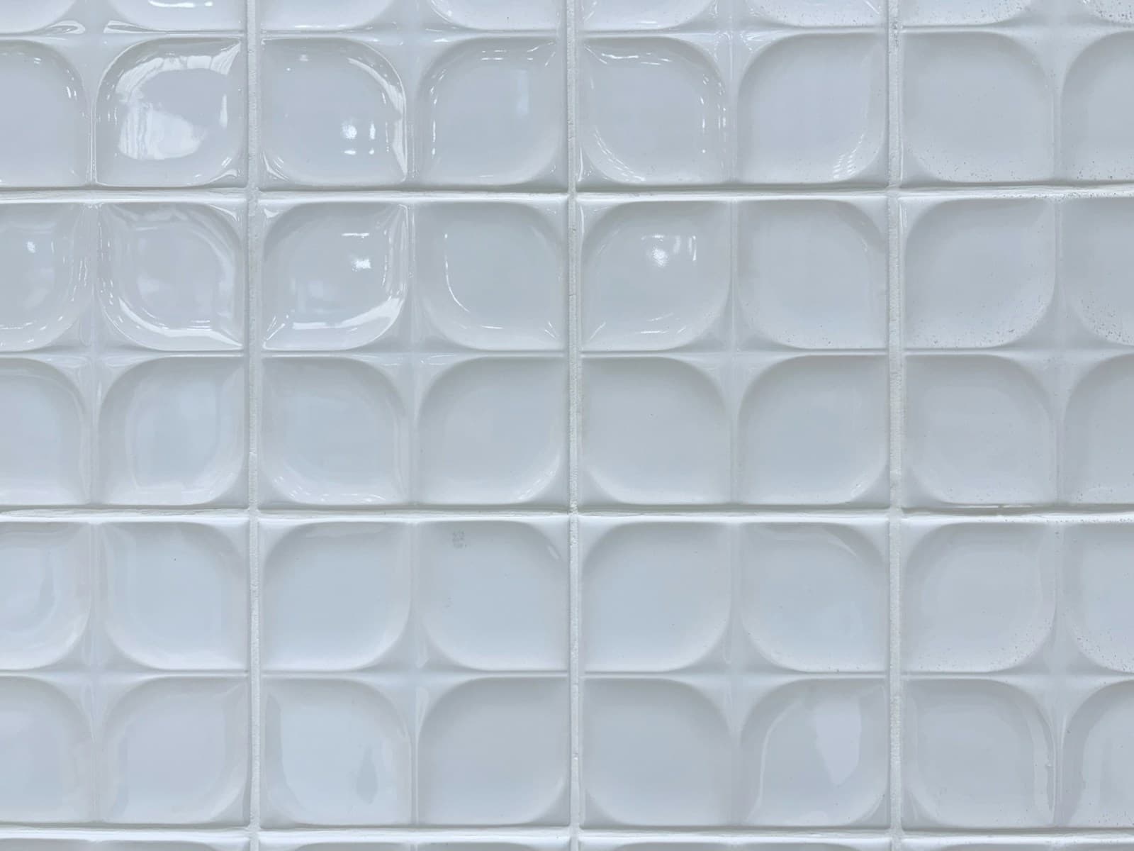 Close-up of glossy white tiles with clean grout lines