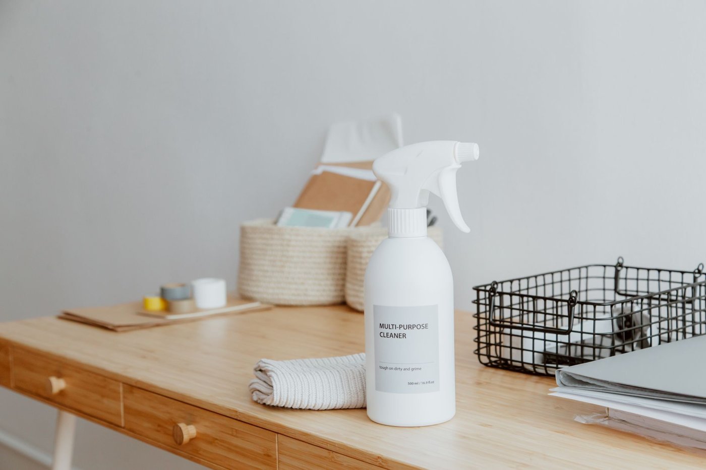 A multi-purpose cleaner spray bottle on a wooden table